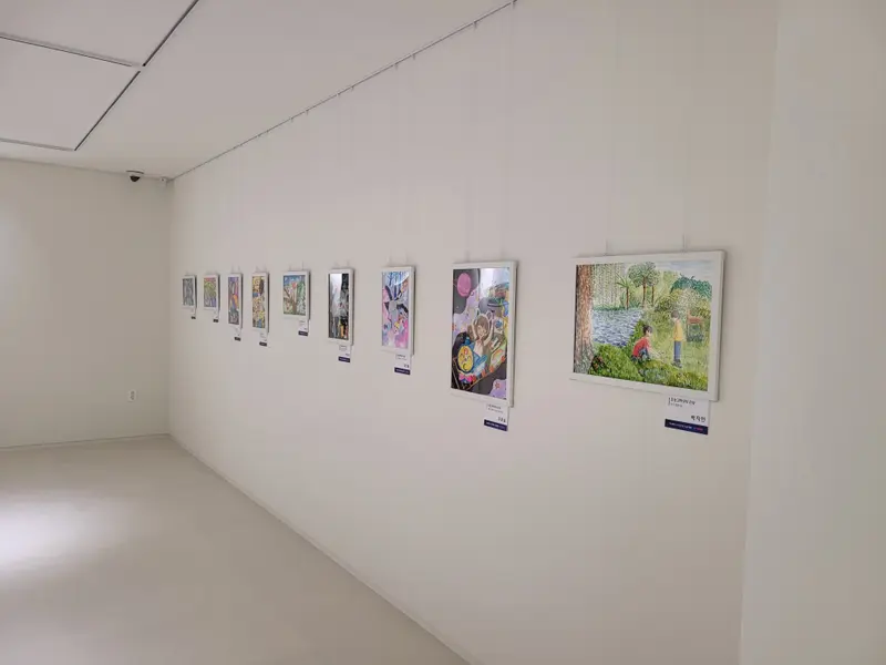 전시장 벽과 가벽에 작품을 한 줄로 설치 사진 7